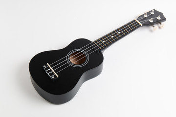 Obraz na płótnie Canvas black ukulele guitar on white background