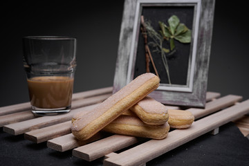 Ladyfinger biscuits for a Classic tiramisu dessert and a glass cup of coffee for dipping