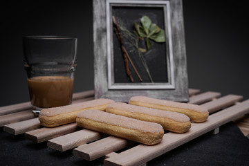 Ladyfinger biscuits for a Classic tiramisu dessert and a glass cup of coffee for dipping
