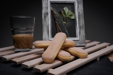 Ladyfinger biscuits for a Classic tiramisu dessert and a glass cup of coffee for dipping
