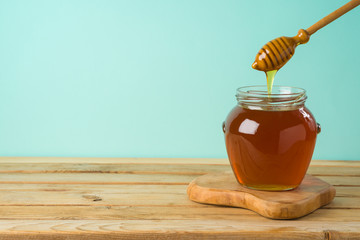 Jewish holiday Rosh Hashana background with honey jar on wooden table