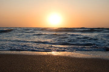 Sunset or dawn on the sea, waves and the sun.