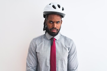 African american businessman with braids wearing bike helmet over isolated white background skeptic and nervous, disapproving expression on face with crossed arms. Negative person.