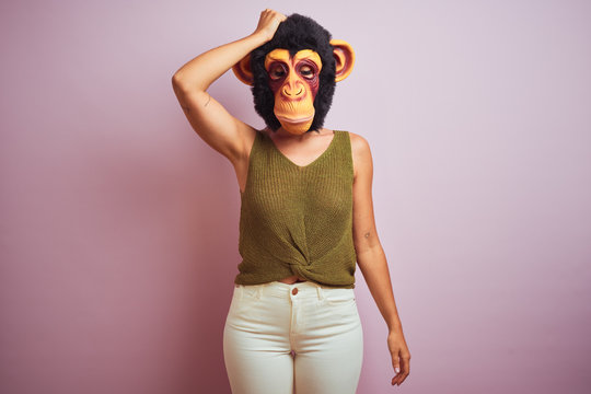 Woman standing wearing t-shirt and monkey mask