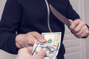 Robber with knife steals money, men's hands, cropped photo, close up, ton