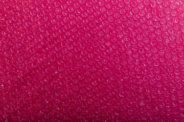 Abstract bubble background. Polyethylene pink-red texture background. Cropped shot, horizontal,...