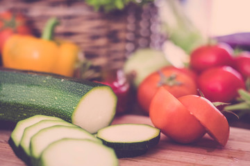 closeup of table full of food with nobody in the photo - vegetables like tomatoes, zucchini and pepper - vegan and vegetarian concept and lifestyle - vitamins and diet food