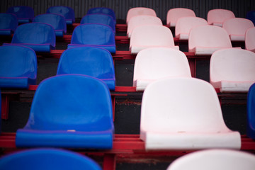 Rows of white and blue seats in a stadium.