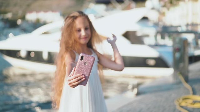 Kid girl taking selfie photo on smartphone