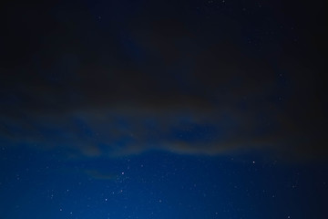 blue starry sky through gray clouds