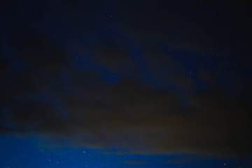 Fototapeta na wymiar blue starry sky through gray clouds
