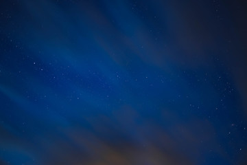 blue starry sky through gray clouds