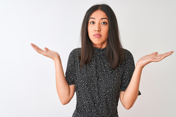 Young chinese woman wearing elegant t-shirt standing over isolated white background clueless and...