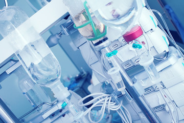 Intravenous drip with saline bottles on the background of digital equipment