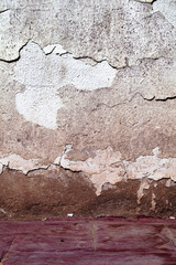 Weathered plastered wall with deep cracks as an old texture background