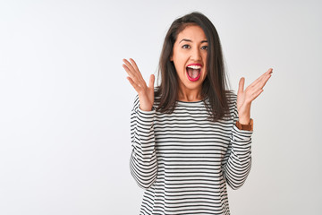 Young beautiful chinese woman wearing striped t-shirt standing over isolated white background celebrating crazy and amazed for success with arms raised and open eyes screaming excited. Winner concept