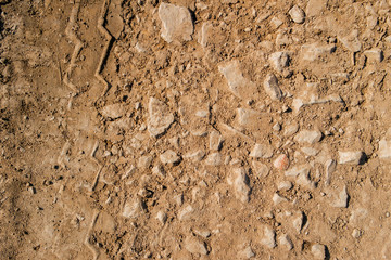 Dry soil texture and background. Red soil background. Abstract ground. Natural abstraction. Clay. Ocher. Red sands. Tire tracks. Clayey ground. Stony ground