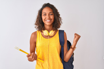 Brazilian student woman wearing backpack holding notebook over isolated white background screaming proud and celebrating victory and success very excited, cheering emotion - obrazy, fototapety, plakaty
