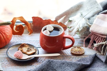Obraz na płótnie Canvas Cup of coffee, meringues, pumpkins, leaves, plaid on a window background, home comfort concept, Thanksgiving, autumn season