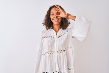 Naklejka premium Young brazilian woman wearing shirt standing over isolated white background doing ok gesture with hand smiling, eye looking through fingers with happy face.