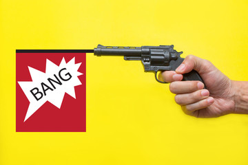 Hand holding gun with bang flag