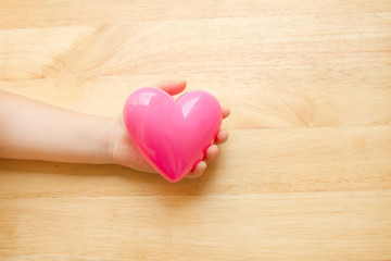 Kid hand holding heart.concept of love or care