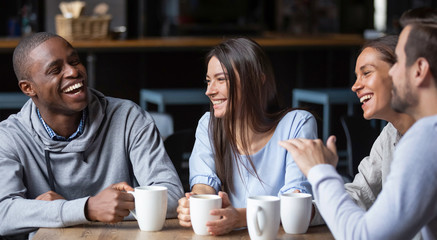 Multiracial friends girls and guys having fun laughing drinking coffee - Powered by Adobe