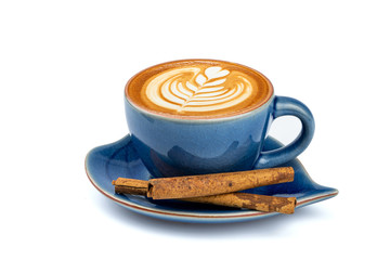 Side view of hot latte coffee with latte art and cinnamon sticks in a ceramic blue cup and saucer isolated on white background with clipping path inside. Image Stacking Techniques.