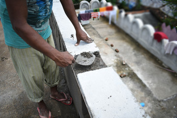 A worker plastering wall with concrete cement mixture using a trowel