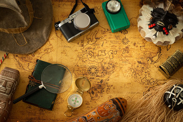 Souvenirs from travels around the world. Map with a travel notebook and travel equipment in a retro...