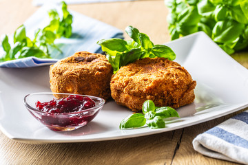 Fried camembert or brie cheese with cranberry jam and basil