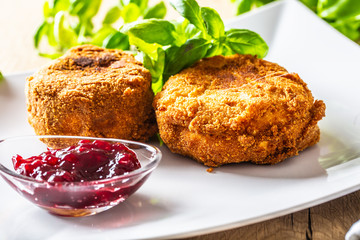 Fried camembert or brie cheese with cranberry jam and basil