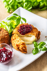 Fried camembert or brie cheese with cranberry jam and basil