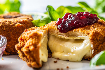 Fried camembert or brie cheese with cranberry jam and basil