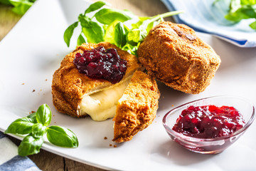 Fried camembert or brie cheese with cranberry jam and basil