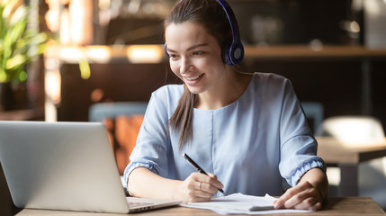 Smiling girl wear wireless headphone study online with skype teacher - obrazy, fototapety, plakaty