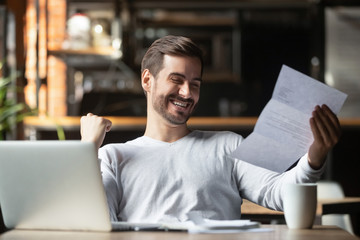 Excited businessman reading postal mail letter overjoyed by great news