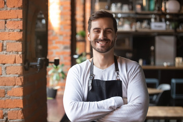 Obraz premium Happy confident young waiter entrepreneur looking at camera, portrait