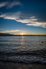 Short waves crash on Lakeside Beach at Lake Tahoe during sunset with mountains splitting the middle of the picture