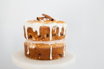 cardamom cake with lingonberries, brown butter cinnamon frosting and cream cheese glaze, white background, copy space