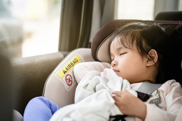 Asian baby cute girl sleeping or relaxing on car seat in heavy traffic day in the morning time.