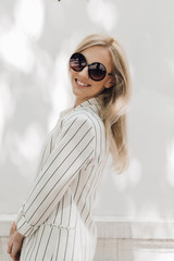 Stylish young woman in sunglasses walks in the city