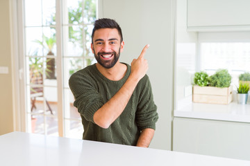 Handsome man pointing with arms and fingers, smiling cheerful with big smile on face