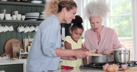 Three generations of family cooking a meal together