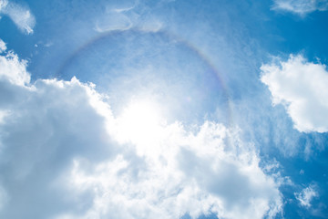 Corona with cloud in the blue sky. Rainbow halo around the sun with cloud in the blue sky. - Image
