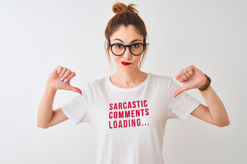 Redhead woman wearing funny t-shirt with irony comments over isolated white background with angry face, negative sign showing dislike with thumbs down, rejection concept