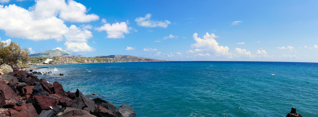 Santorini, Greece, April 2019. Scenic view of the  sea, red rocks, blue sky, clouds on the island...