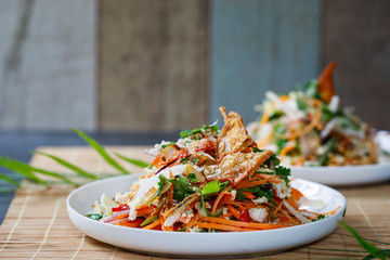 Thai salad with fresh vegetables, poached chicken and crispy chicken skin