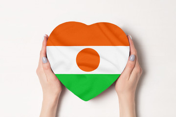 Flag of Niger on a heart shaped box in a female hands. White background