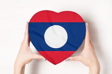 Flag of Laos on a heart shaped box in a female hands. White background
